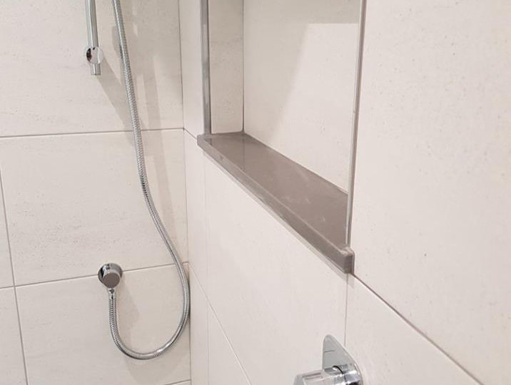Tiled Shower With Shelf & Silver Fixtures