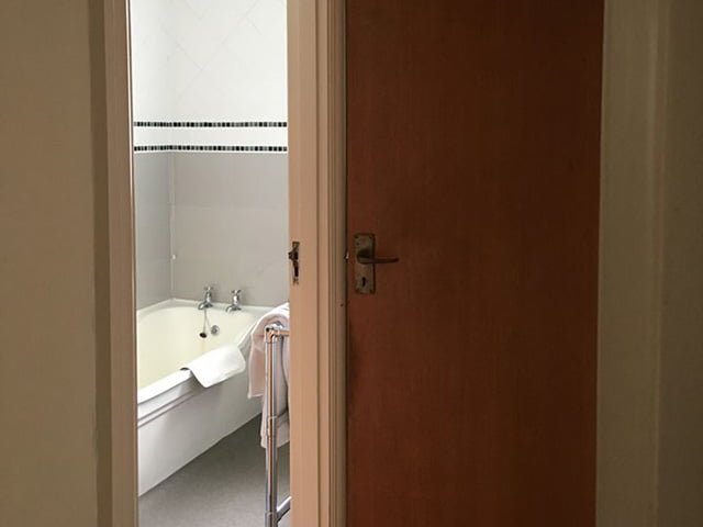 Before Photo of Doorway into Bathroom Showing Tub